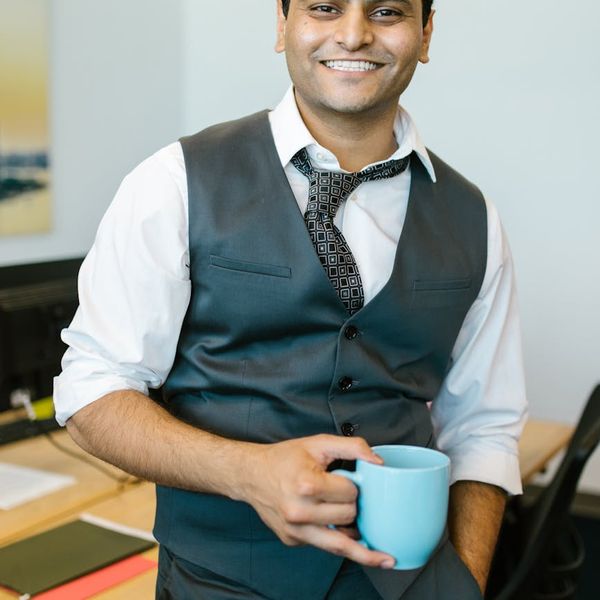 Smiling person stretching at their office desk, feeling refreshed