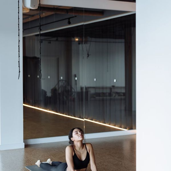 Woman practicing a peaceful yoga pose in a bright, modern studio